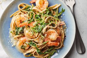 overhead shot of pasta with shrimp in a blue bowl
