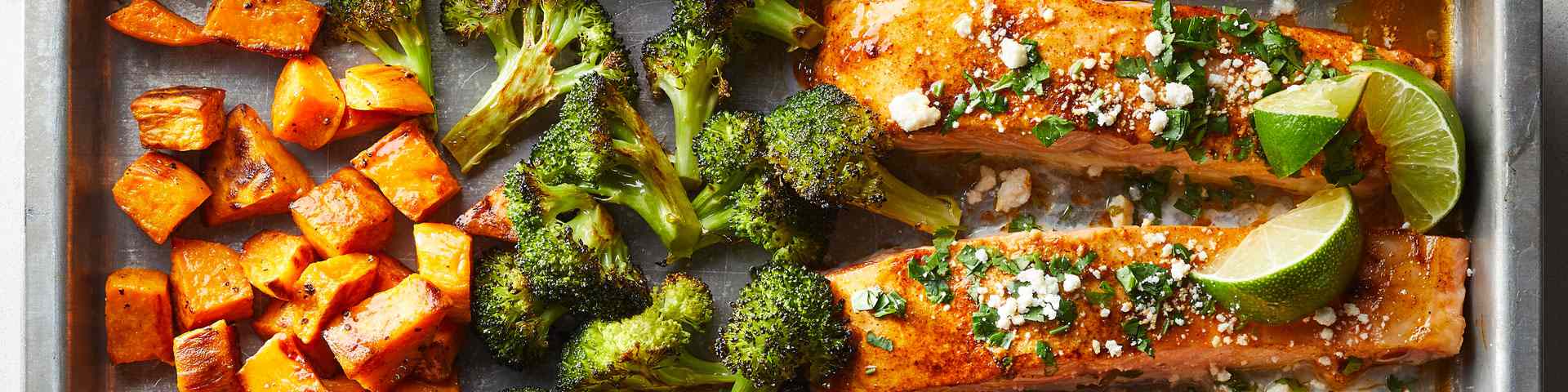 overhead shot of broccoli, sweet potato and salmon on a sheet-pan