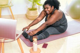 a photo of a woman exercising at home on a yoga mat 