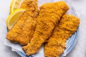 a recipe photo of Crispy Baked Catfish with sauce and lemon beside it