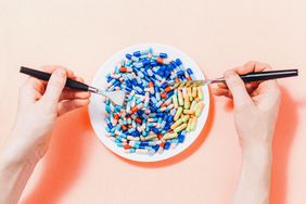a photo of hands holding a knife and work, digging into a plateful of pills
