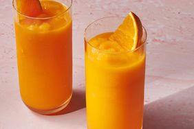 a recipe photo of the Carrot Smoothie served in two glasses with orange slices for garnish