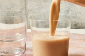 a recipe photo of the Homemade Oat Milk being poured into a glass