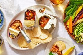 Canned fish, vegetables and crackers on a tablecloth