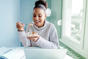 a photo of a woman eating overnight oats for breakfast at her desk