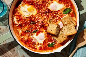 Horizontal image of Vodka Sauce Eggs overhead in a skillet with bread