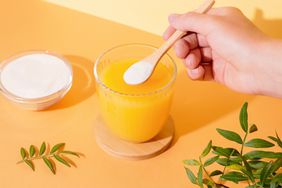 a photo of someone putting Vitamin C powder into their drink