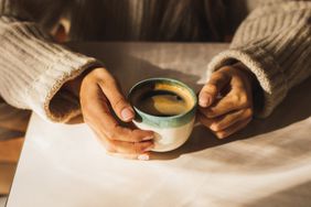 a photo of a person holding a cup of coffee 