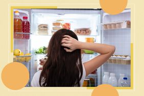 a photo of a woman looking confused while looking at her fridge